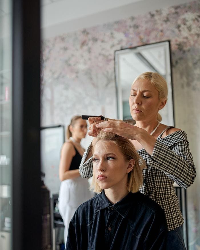 Stylizacja krótkiego blond boba grzebieniem podczas strzyżenia